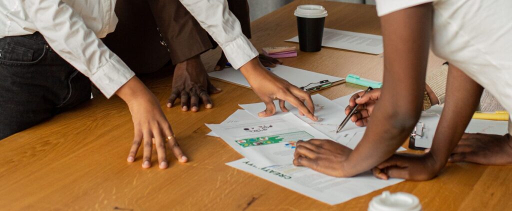 A diverse group of professionals engaged in a brainstorming session around a work table.